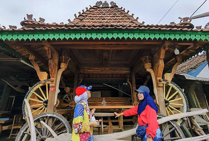 Pekerja menyelesaikan tahap produksi kerajinan produk mebel dan kerajinan berbahan dasar kayu jati dan mahoni di Pati, Jawa Tengah, Minggu (25/12/2022).