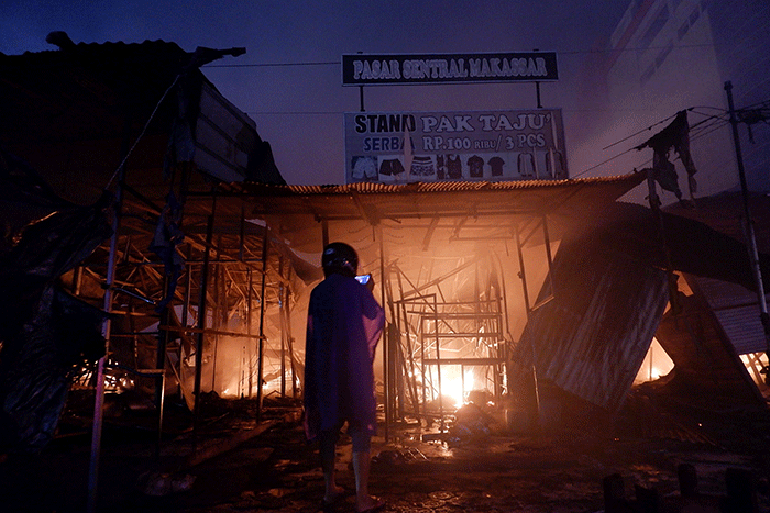 Petugas pemadam kebakaran berusaha memadamkan api yang membakar ratusan lapak pedagang di Pasar Sentral, Makassar, Selasa (27/12/2022).