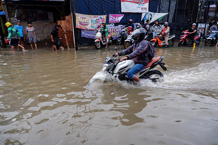 Sejumlah pengendara nekad menerobos banjir di Jalan Nipa-nipa, Kecamatan Manggala, Makassar, Rabu (28/12/2022).
