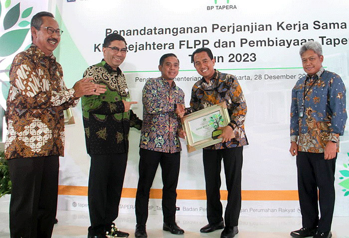 Direktur Consumer Bank BTN Hirwandi Gafar (kedua kanan) menunjukkan naskah perjanjian kerja sama penyaluran KPR Sejahtera FLPP dan Pembiayaan Tapera.