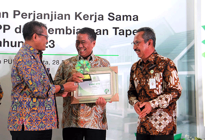 Direktur Consumer Bank BTN Hirwandi Gafar (kedua kanan) menunjukkan naskah perjanjian kerja sama penyaluran KPR Sejahtera FLPP dan Pembiayaan Tapera.