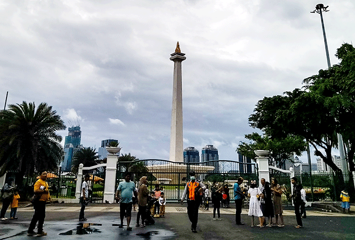 Pengunjung tetap datang berlibur ke kawasan Monas dari luar walaupun peringatan cuaca hujan disertai angin melanda Jakarta, Rabu (28/12/2022).