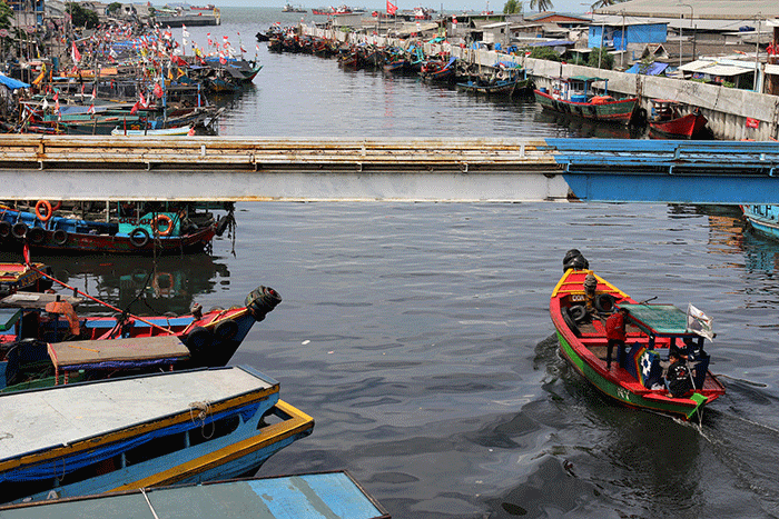 Nelayan memperbaiki jaring yang rusak di Kampung Nelayan Cilincing, Jakarta, Jumat (30/12/2022).