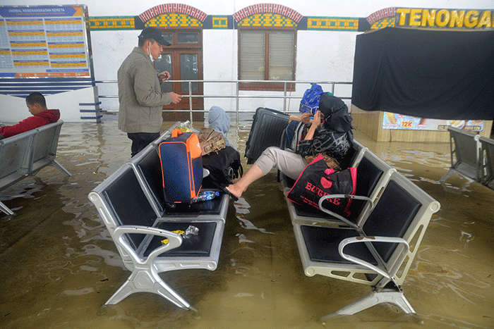 Aktivitas penumpang di Stasiun Semarang Tawang di tengah genangan banjir, Sabtu (31/12/2022).