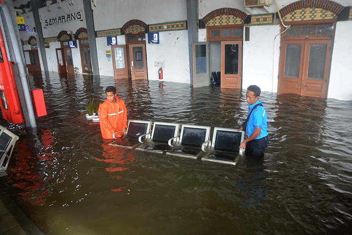Aktivitas penumpang di Stasiun Semarang Tawang di tengah genangan banjir, Sabtu (31/12/2022).