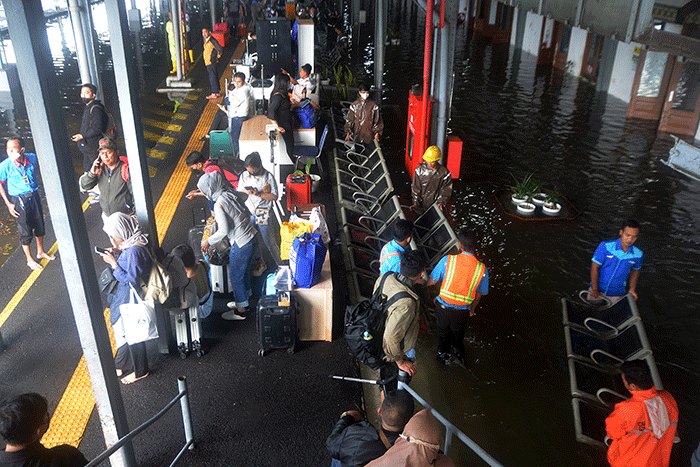Aktivitas penumpang di Stasiun Semarang Tawang di tengah genangan banjir, Sabtu (31/12/2022).
