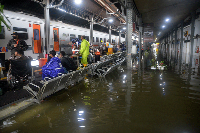 Aktivitas penumpang di Stasiun Semarang Tawang di tengah genangan banjir, Sabtu (31/12/2022).