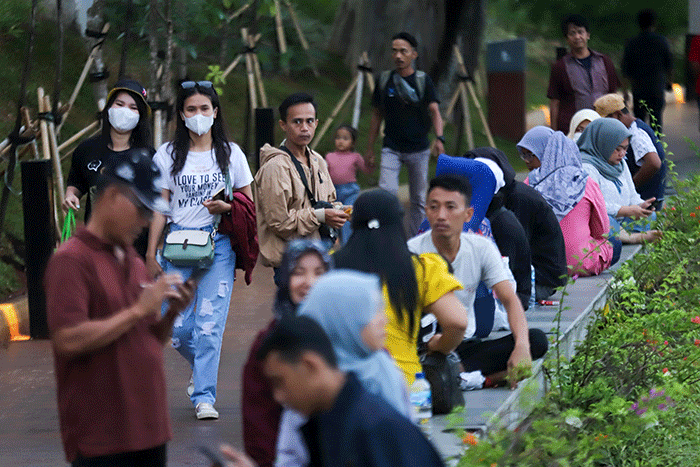 Pengunjung beraktivitas saat berwisata di Taman Mini Indonesia Indah (TMII), Jakarta Timur, Sabtu (31/12/2022).