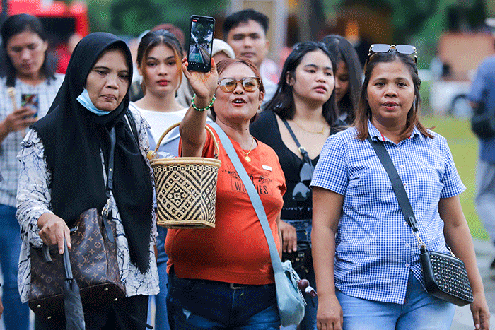 Pengunjung beraktivitas saat berwisata di Taman Mini Indonesia Indah (TMII), Jakarta Timur, Sabtu (31/12/2022).