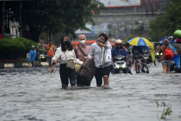 Sejumlah warga harus berjibaku menerjang banjir di kawasan titik nol (KM 0) Semarang, Jawa Tengah, Sabtu (31/12/2022).
