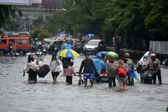 Sejumlah warga harus berjibaku menerjang banjir di kawasan titik nol (KM 0) Semarang, Jawa Tengah, Sabtu (31/12/2022).