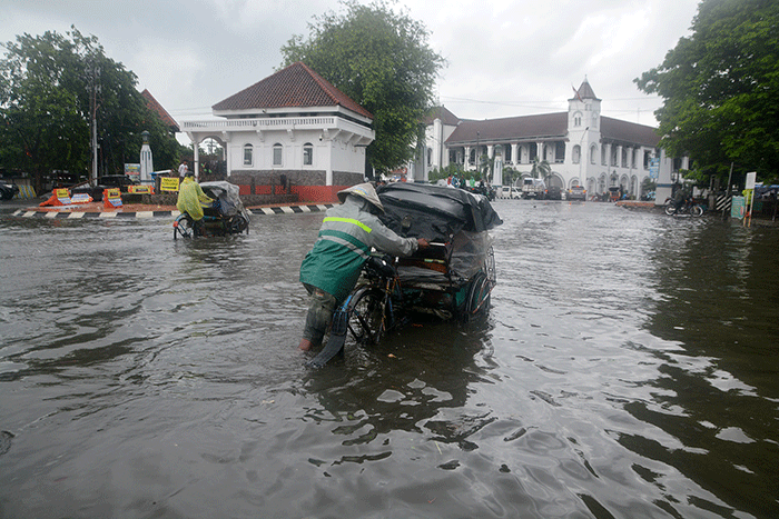 Sejumlah warga harus berjibaku menerjang banjir di kawasan titik nol (KM 0) Semarang, Jawa Tengah, Sabtu (31/12/2022).