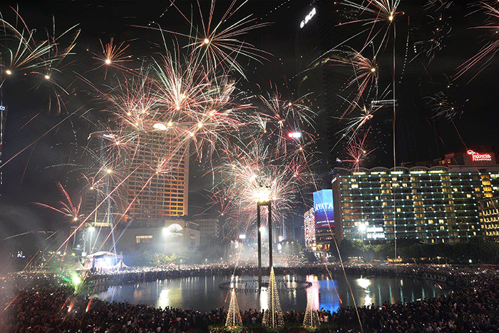 Suasana pesta kembang api saat malam perayaan tahun baru 2023 di kawasan Bundaran HI, Jakarta, Minggu (1/1/2023).