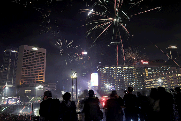 Suasana pesta kembang api saat malam perayaan tahun baru 2023 di kawasan Bundaran HI, Jakarta, Minggu (1/1/2023).