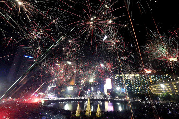 Suasana pesta kembang api saat malam perayaan tahun baru 2023 di kawasan Bundaran HI, Jakarta, Minggu (1/1/2023).