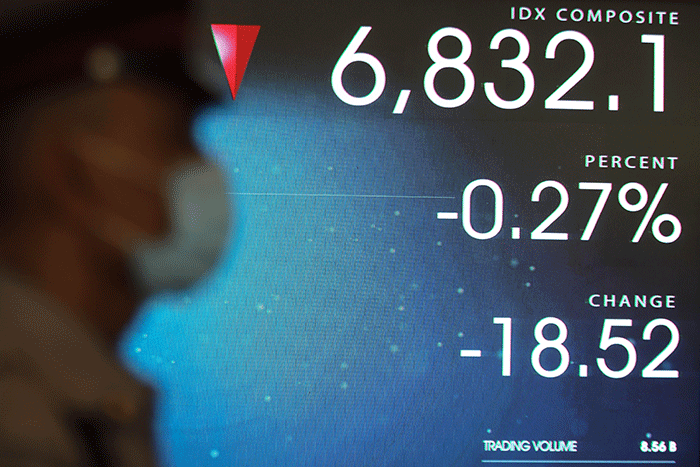 Pekerja melintasi Layar pergerakan Indeks Harga Saham Gabungan (IHSG) di Gedung Bursa Efek Indonesia, Jakarta, Senin (2/1/2023).