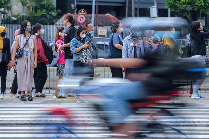 Pekerja melintas saat jam pulang kerja di Kawasan Thamrin, Jakarta Pusat, Senin (2/1/2023).