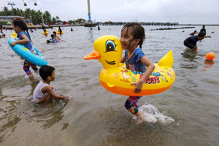 Pengunjung memadati kawasan Pantai Taman Impian Jaya Ancol, Jakarta, Minggu (1/1/2023).