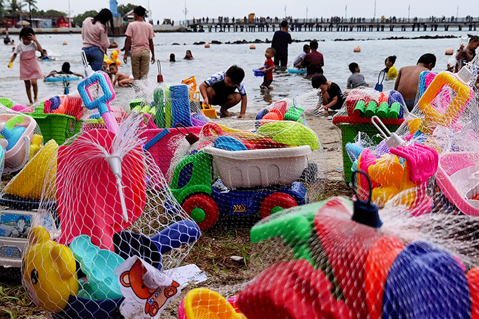 Pengunjung memadati kawasan Pantai Taman Impian Jaya Ancol, Jakarta, Minggu (1/1/2023).