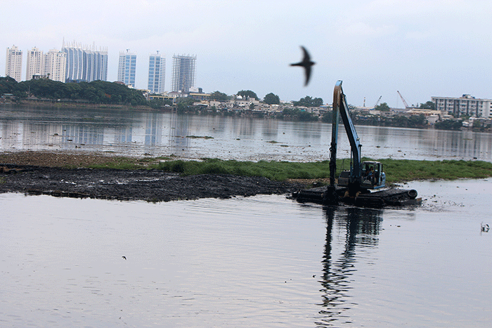 Petugas Suku Dinas Sumber Daya Air mengunakan Alat berat melakukan pengerukan Waduk Pluit, Penjaringan, Jakarta Utara, Selasa (3/1/2023).