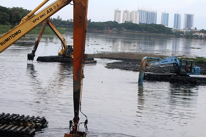 Petugas Suku Dinas Sumber Daya Air mengunakan Alat berat melakukan pengerukan Waduk Pluit, Penjaringan, Jakarta Utara, Selasa (3/1/2023).