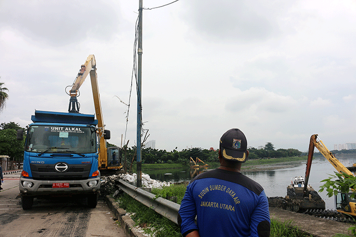 Petugas Suku Dinas Sumber Daya Air mengunakan Alat berat melakukan pengerukan Waduk Pluit, Penjaringan, Jakarta Utara, Selasa (3/1/2023).