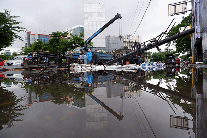 Sejumlah pekerja mengangkat reklame yang tumbang di perempatan Jalan Metro Tanjung Bunga, Makassar, Rabu (4/1/2023).
