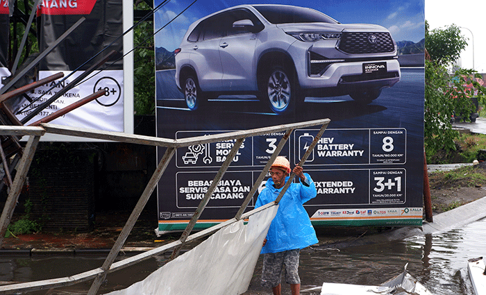 Sejumlah pekerja mengangkat reklame yang tumbang di perempatan Jalan Metro Tanjung Bunga, Makassar, Rabu (4/1/2023).