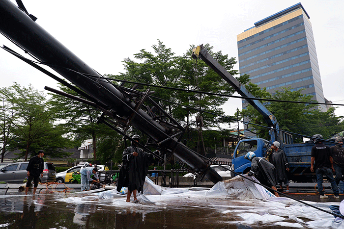 Sejumlah pekerja mengangkat reklame yang tumbang di perempatan Jalan Metro Tanjung Bunga, Makassar, Rabu (4/1/2023).