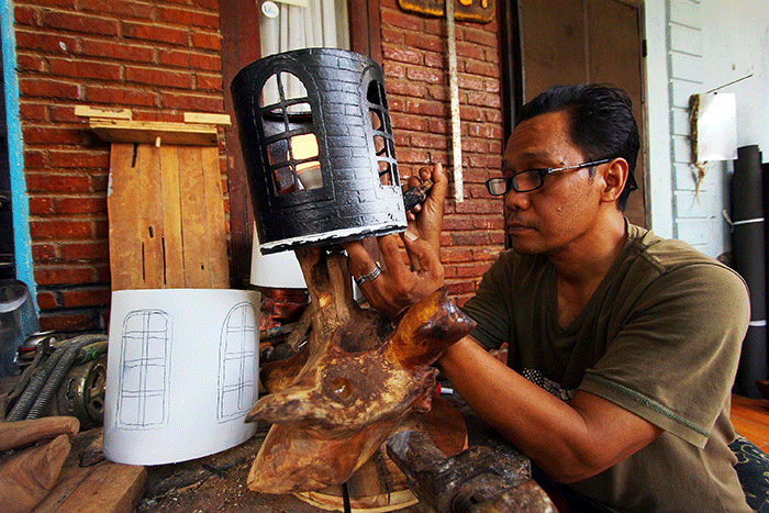 Perajin menyelesaikan pembuatan lampu hias dengan berbahan baku sampah plastik atau plastik tempat cat juga limbah kayu di kawasan Pamulang, Tangerang Selatan.