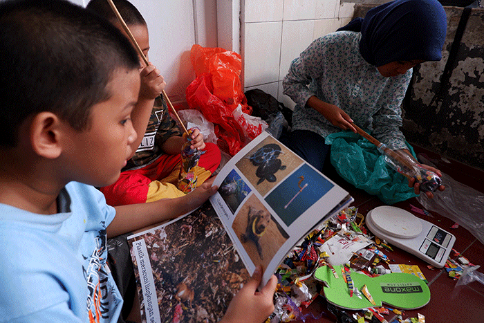 Audi Nisfatul Aira siswi kelas 2 bersama adiknya membuat ecobrik sebagai upaya meminimalisir sampah plastik di lingkungan rumahnya, Makassar.