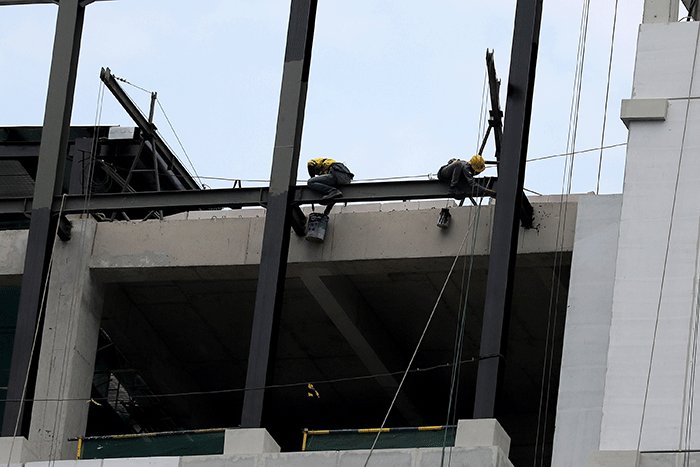 Sejumlah pekerja menyelesaikan pembangunan gedung di kawasan Sudirman, Jakarta, Sabtu (14/1/2023).