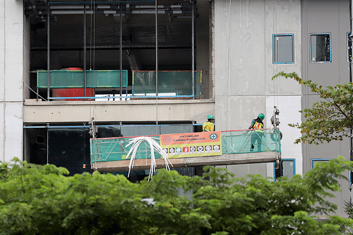Sejumlah pekerja menyelesaikan pembangunan gedung di kawasan Sudirman, Jakarta, Sabtu (14/1/2023).