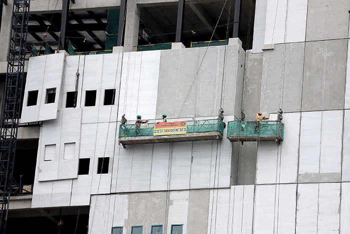Sejumlah pekerja menyelesaikan pembangunan gedung di kawasan Sudirman, Jakarta, Sabtu (14/1/2023).