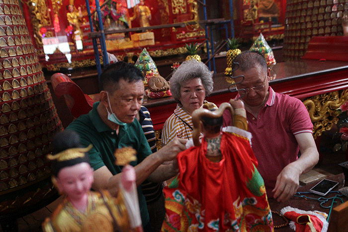 Warga keturunan Tionghoa membersihkan patung dewa di Kelenteng Xian Ma, Makassar, Senin (16/1/2023).