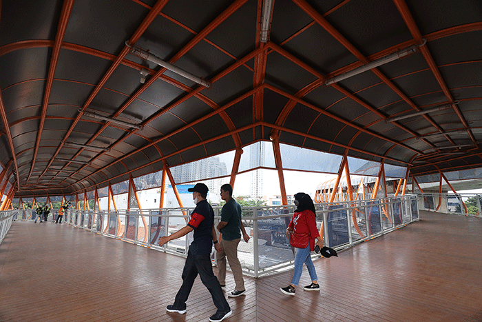 Warga berjalan di Skywalk yang menghubungkan antara Stasiun KRL Kebayoran dan Halte Bus Velbak di Kebayoran Lama, Jakarta Selatan, Sabtu (21/1/2023).