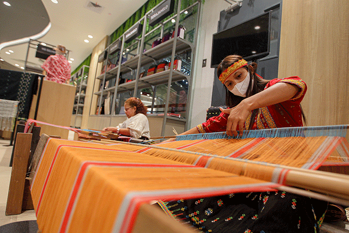 Pengerajin asal Kabupaten Manggarai Nusa Tenggara Timur (NTT) saat menyelesaikan pembuatan kain tenun di Mal Sarinah, Jakarta, Senin (23/1/2023).