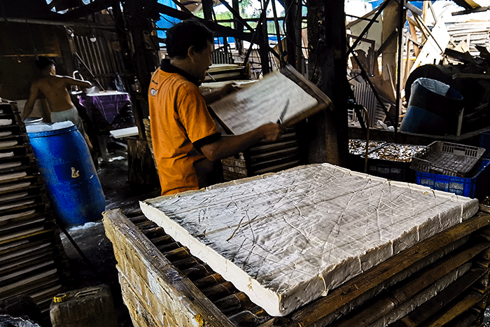 Perajin mencetak tahu di rumah produksinya di kawasan Jakarta Barat, Jumat (27/1/2023).