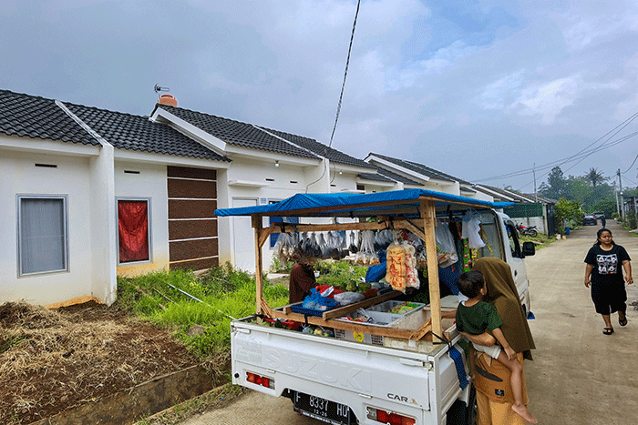 Pedagang kebutuhan pokok saat melayani pembeli penghuni perumahan KPR Bersubsidi di Puri Ciseeng Lestari, Bogor, Minggu, (29/1/2023).
