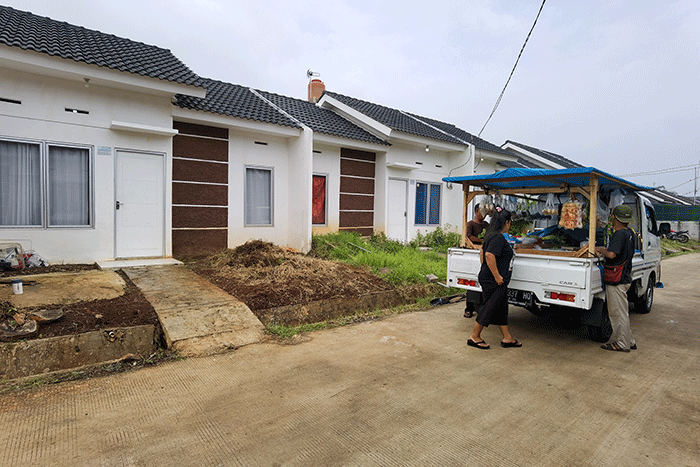 Pedagang kebutuhan pokok saat melayani pembeli penghuni perumahan KPR Bersubsidi di Puri Ciseeng Lestari, Bogor, Minggu, (29/1/2023).