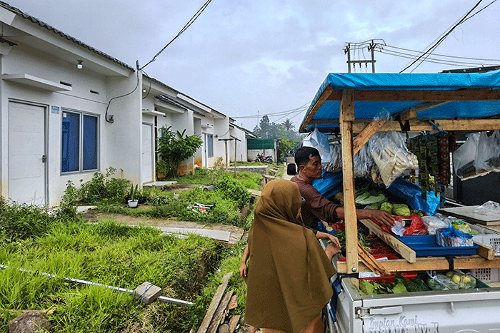 Pedagang kebutuhan pokok saat melayani pembeli penghuni perumahan KPR Bersubsidi di Puri Ciseeng Lestari, Bogor, Minggu, (29/1/2023).