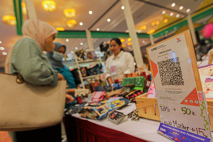 Pembeli membayar menggunakan QRIS dalam acara pameran UMKM di Jakarta, Jumat (3/2/2023).