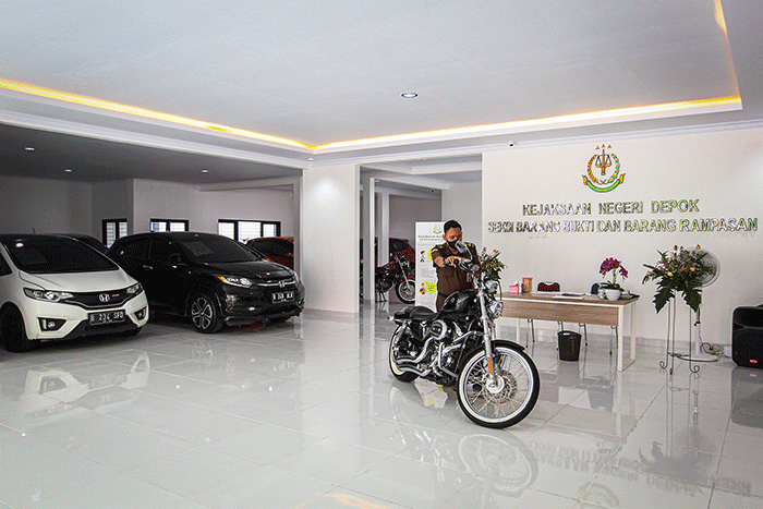 Petugas saat melalukan pengecekan kendaraan barang bukti rampasan yang akan dilelang di Galeri Penyimpanan Barang Bukti Kejaksaan Negeri Depok.