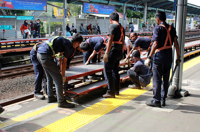 Sejumlah pekerja memasang tangga untuk pengguna KRL di Stasiun Tebet, Jakarta Selatan, Senin (6/2/2023).