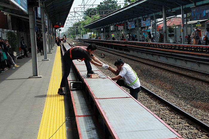 Sejumlah pekerja memasang tangga untuk pengguna KRL di Stasiun Tebet, Jakarta Selatan, Senin (6/2/2023).