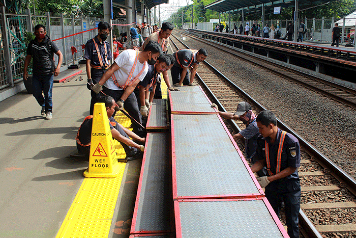 Sejumlah pekerja memasang tangga untuk pengguna KRL di Stasiun Tebet, Jakarta Selatan, Senin (6/2/2023).