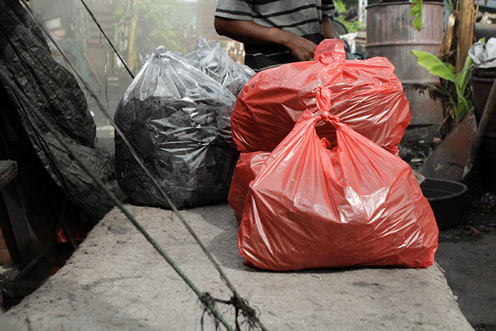 Pekerja membuat arang dari bahan batok kelapa di kawasan Jakarta Pusat, Rabu (8/2/2023).