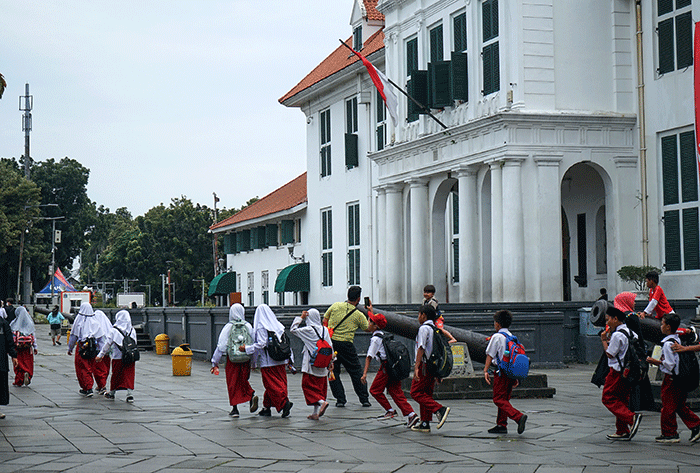 Warga berjalan di trotoar di kawasan wisata Kota Tua, Jakarta, Selasa (7/2/2023).