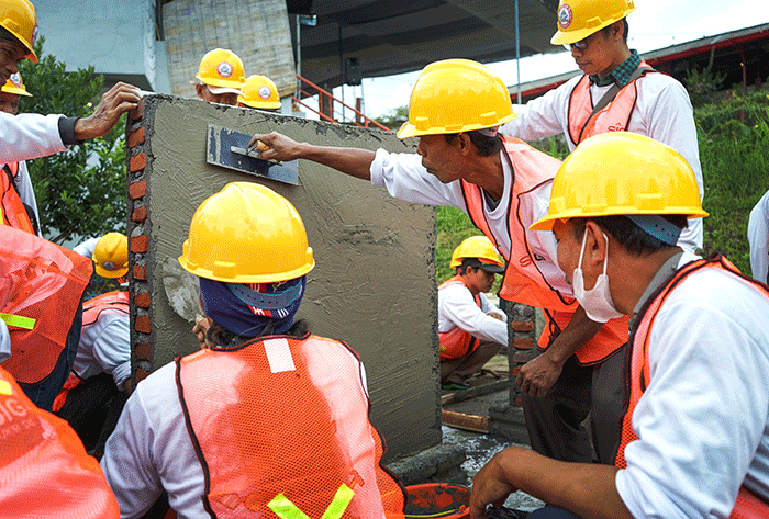 Tenaga konstruksi praktik mengerjakan acian dinding saat pelatihan Ahli Konstruksi (AKSI) di Cafe Abundacio, Kabupaten Malang, Jawa Timur.