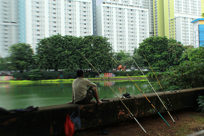 Warga memancing di Danau Sunter, Jakarta Utara, Minggu (12/2/2023).